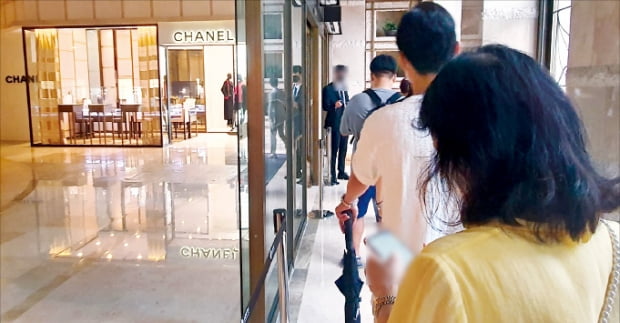 지난 11일 서울 중구 롯데백화점 에비뉴엘 샤넬 매장 앞에 사람들이 줄지어 서 있다. 이날은 샤넬이 주요 제품 가격을 평균 5% 올린 다음 날이었다.   이미경 기자 