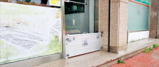 지난 26일 서울 서초구 방배동 남태령 전원마을 한 상가에 차수판이 설치돼 있다.  권용훈 기자
 