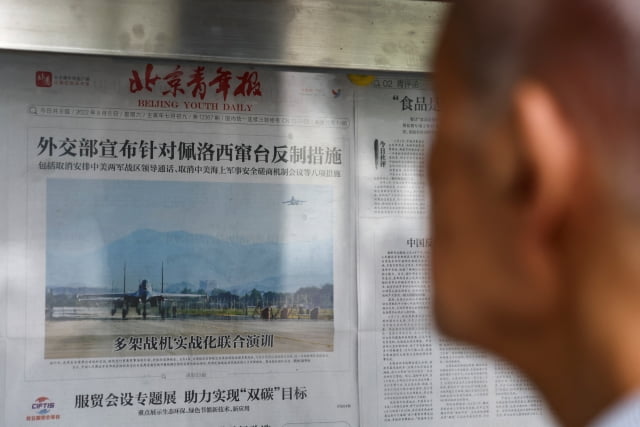 8일 중국 베이징 신문 가판대에서 한 시민이 대만을 둘러싼 인민해방군 동부전구의 군사훈련 모습을 담은 신문 1면을 읽고 있다. / 사진=연합뉴스