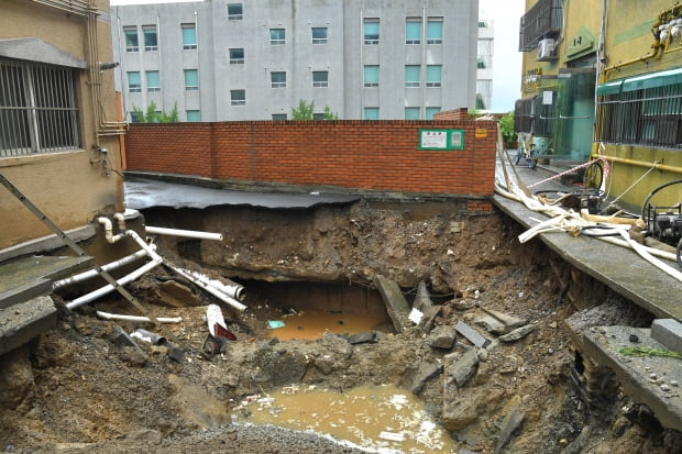  9일 서울 양천구 신월7동의 한 주택가에  전날 내린 폭우로 도로 침하가 발생해 위태로운 모습을 보이고 있다. 사진=뉴스1