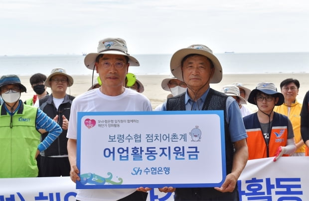 송재영 Sh수협은행 부행장이 조용덕 점치어촌계장에게 지원금을 전달하고 있다. 수협은행 제공