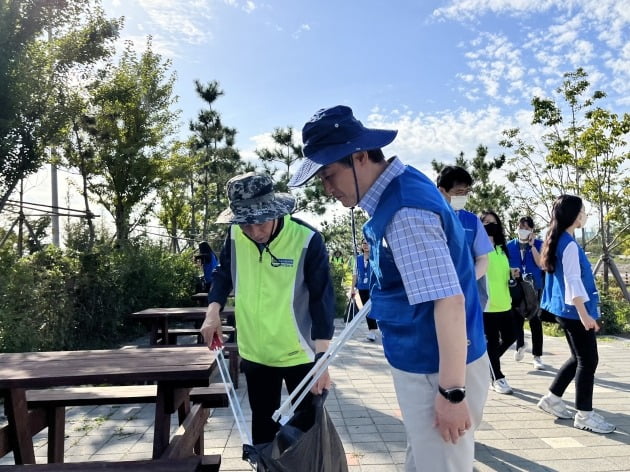 김춘안 농협은행 부행장(왼쪽)과 안병옥 한국환경공단 이사장이 지난 23일 인천 아라뱃길에서 쓰레기를 주우며 조깅하는 '플로깅' 활동을 펼치고 있다. 농협은행 제공