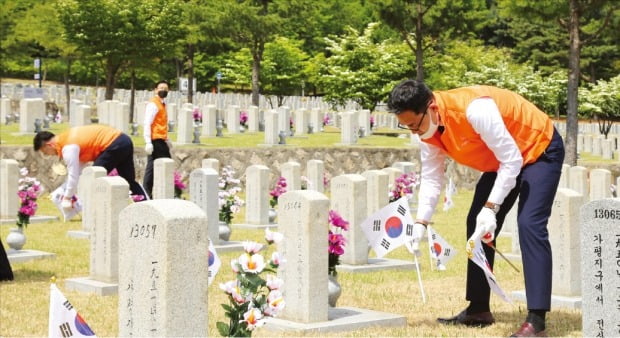 한화 방산계열사 임직원들이 국립서울현충원을 찾아 묘역 정화 활동을 하고 있다. /한화그룹 제공
 