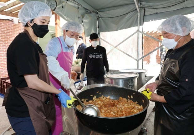 윤석열 대통령이 추석 연휴 첫날인 9일 서울 중구 명동성당 내 무료급식소인 명동밥집에서 백광진 명동밥집 센터장과 김치찌개를 만들고 있다. 사진=연합뉴스