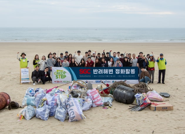 21일 충남 보령시 원산도해수욕장에서 SGC솔루션 임직원들과 국제구호개발 NGO 휴먼인러브 관계자들이 해안 정화 활동 후 기념촬영을 하고 있다. SGC솔루션 제공