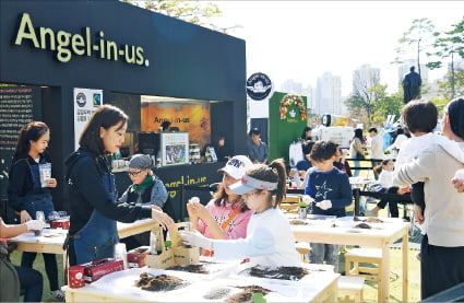 서울 롯데월드타워 잔디광장에서 2019년 열린 ‘청춘, 커피 페스티벌’에 참여한 시민들이 친환경 화분을 만들고 있다.  