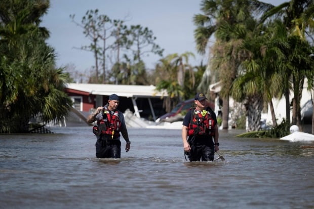 지난달 허리케인 '이언'(Ian)이 휩쓸고 지나간 플로리다주 포트마이어스 주택가에서 미국 구조대원들이 물살을 헤치고 생존자를 수색하고 있다. /사진=AFP