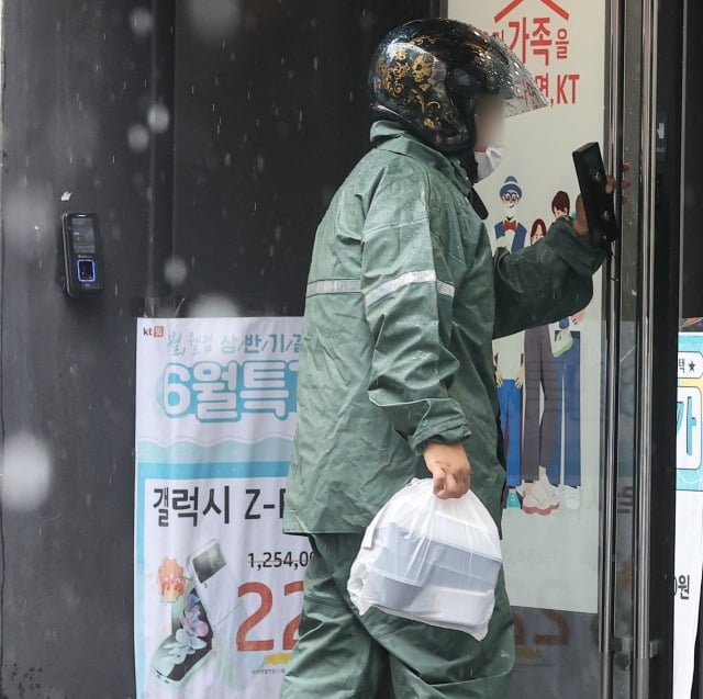 한 배달원이 비가 오는 날 음식을 배달하고 있다. / 사진=연합뉴스
