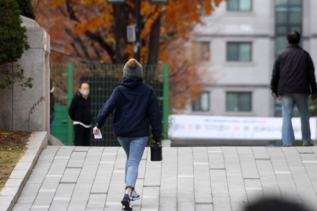 2023학년도 대학수학능력시험이 치러지는 17일 오전 서울 문정동 문정고등학교 서울특별시교육청 제 16 시험지구 제8시험장으로 한 학부모가 수험표와 도시락을 들고 들어가고 있다. 최혁 한경닷컴 기자 chokob@hankyung.com