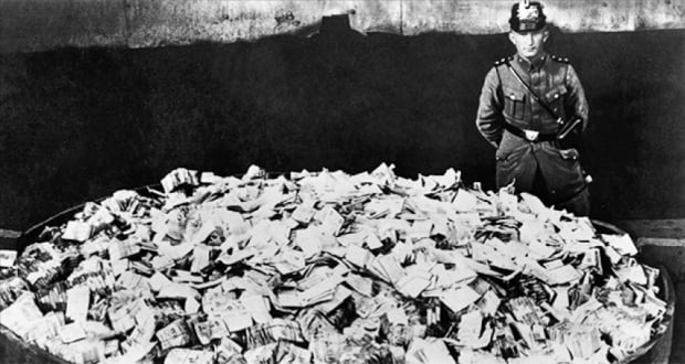 1920년대 초인플레이션에 시달리던 독일에서 가치가 하락한 지폐 더미를 불사르기 위해 모아놓은 장면. 