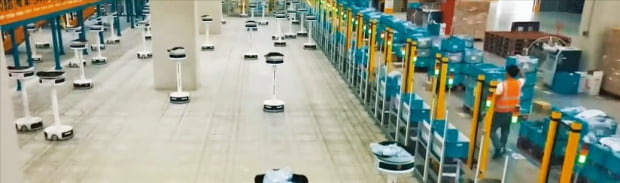쿠팡의 대구 풀필먼트센터 내에 있는 상품 분류 시설에서 로봇들이 분주히 움직이고 있다. 작업자가 물품을 로봇 위에 올려놓으면 로봇이 알아서 주문자 주소와 가장 가까운 배송센터로 향할 쿠팡 차량 앞으로 물품을 가져다 놓는다.  쿠팡  제공 