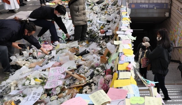 서울 이태원 참사 희생자 추모공간인 이태원역 1번 출구에서 자원봉사자들이 11월 7일 꽃을 정리하고 있다. 연합뉴스