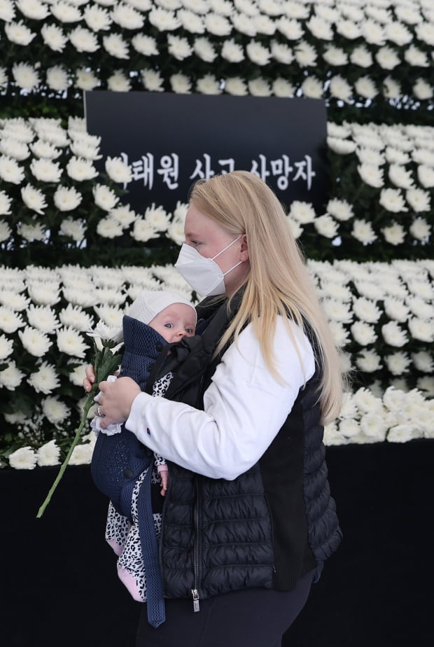 이태원 사고 사망자 합동분향소에서 아이를 안은 외국인이 조문하고 있다 / 사진=연합뉴스