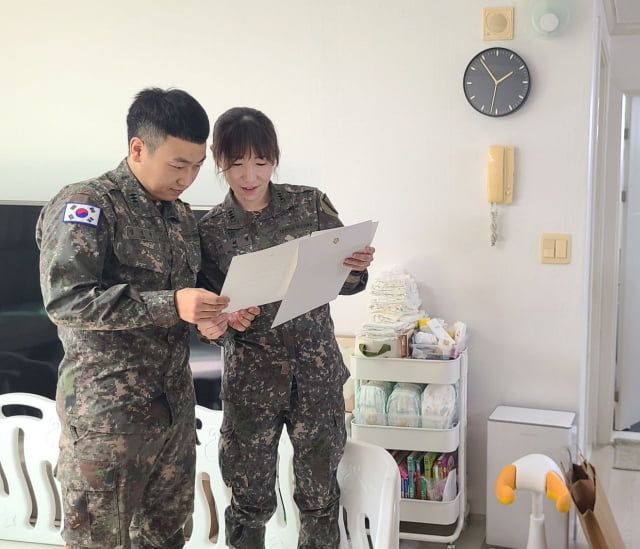 다섯쌍둥이의 부모인 김진수 대위와 서혜정 대위가 김건희 여사의 편지를 읽고 있다. / 사진=대통령실 제공