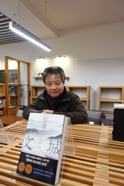 소설가 위화가 서울 광화문의 한 서점에서 자신의 책 <원청>을 바라보고 있다. /푸른숲 제공