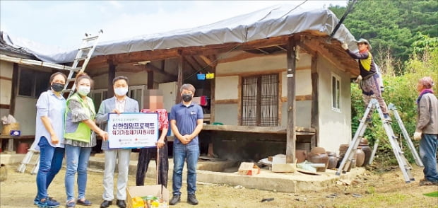 카지노 게임 사이트금융그룹이 지원하는 독거노인 가구 주거환경 개선 공사 현장에서 재단 관계자들과 수혜자가 기념촬영을 하고 있다.  카지노 게임 사이트금융그룹 제공 