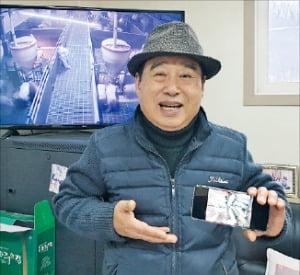 이성권씨가 경기 화성 축사에서 돼지의 건강 상태를 실시간 파악할 수 있는 인공지능(AI) 기술을 설명하고 있다. 뒤쪽 화면은 세종 축사의 폐쇄회로TV(CCTV) 장면.  정의진  기자
 
