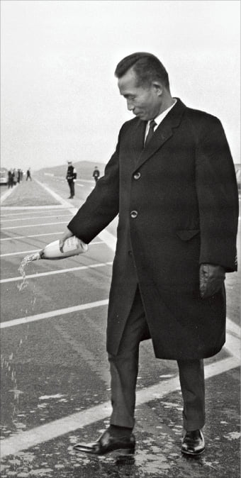 박정희 대통령이 1968년 12월 21일 열린 경인고속도로와 경수고속도로 동시 개통식에서 축하의 뜻을 담아 샴페인을 고속도로 바닥에 뿌리고 있다. 
 한경디지털자산 