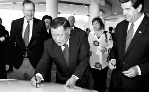 정몽구 현대자동차그룹 회장(가운데)이 2005년 5월 20일 열린 미국 앨라배마 공장 준공식에서 조지 부시 미국 대통령(왼쪽) 등이 지켜보는 가운데 처음 생산된 쏘나타(1호차)에 기념 서명하고 있다.  한경디지털자산 