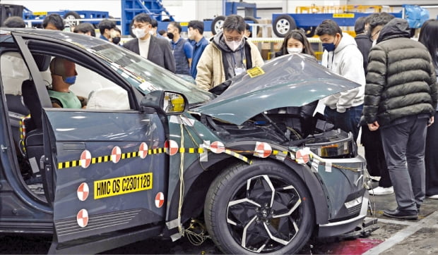 현대자동차그룹 연구원과 취재진이 지난 12일 경기 화성 남양연구소 안전시험동에서 충돌 평가를 한 뒤 아이오닉 5를 살펴보고 있다.  현대차그룹 제공 