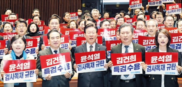 이재명 대표(가운데)와 박홍근 원내대표(왼쪽 두 번째) 등 더불어민주당 의원들이 30일 국회에서 열린 의원총회에서 피켓을 들고 구호를 외치고 있다.  연합뉴스 