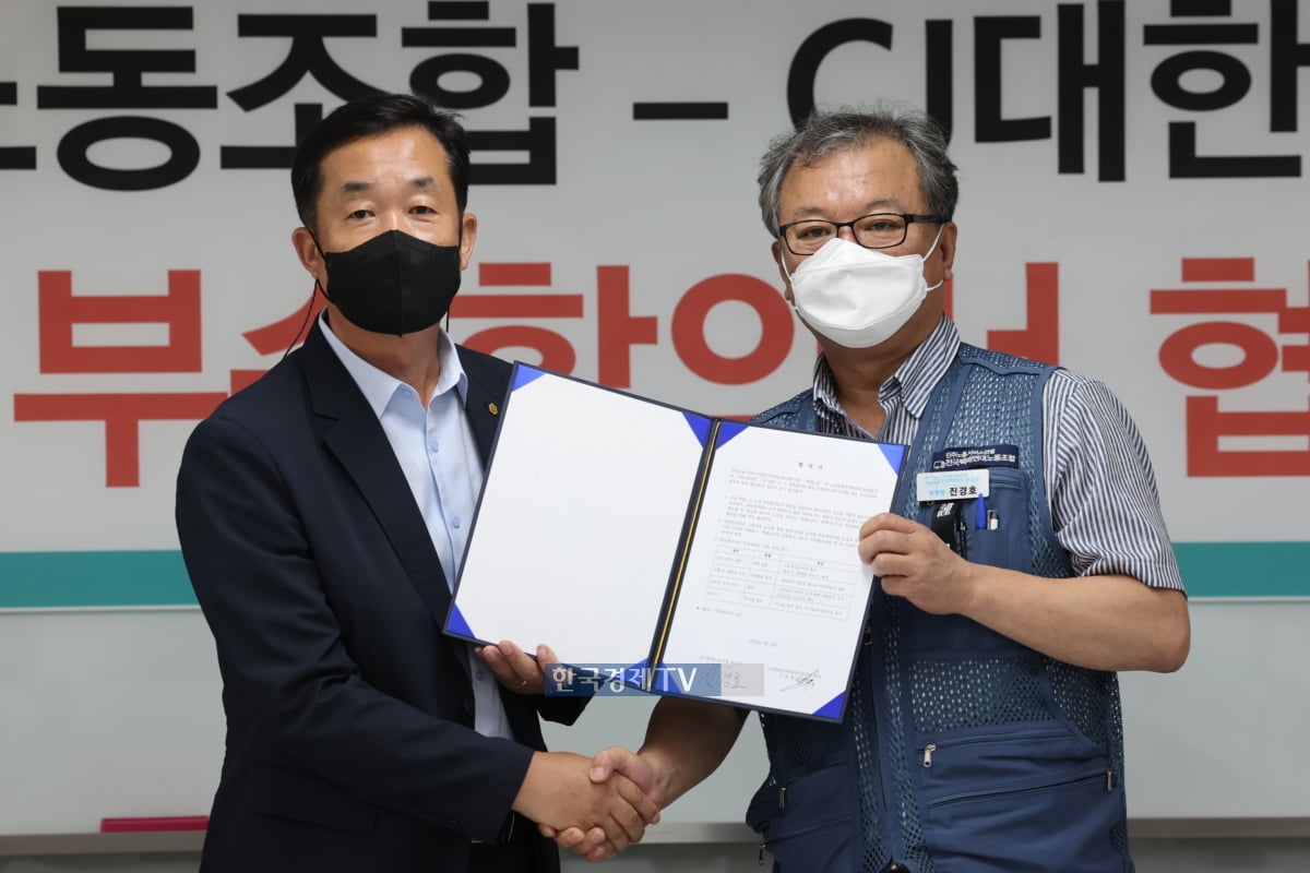 김종철 CJ대한통운대리점연합 회장(사진 좌측)이 지난해 3월 택배노조와 '표준계약서 부속 합의서'에 서명한 뒤 기념촬영을 하고 있다.