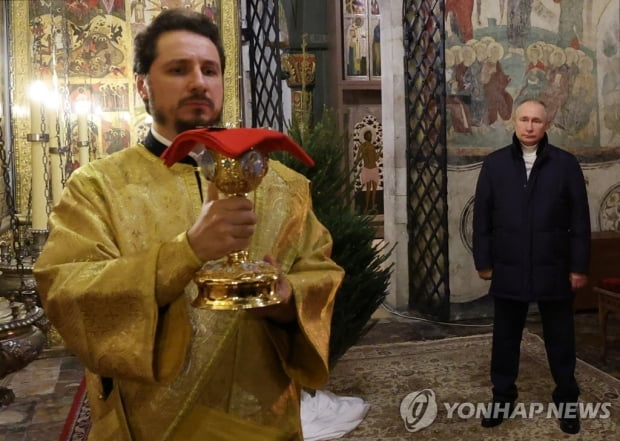 Even on Christmas day, the bombings come and go… Putin crosses himself in the chapel