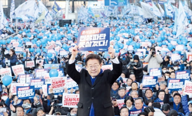 이재명 더불어민주당 대표가 지난 4일 서울 세종대로 숭례문 앞에서 열린 ‘윤석열 정권 민생파탄·검사독재 규탄대회’에서 군중을 배경으로 피켓을 들어 보이고 있다.   뉴스1 