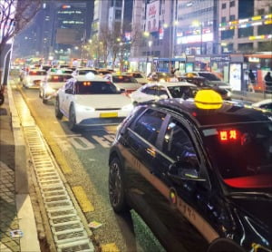 지난 6일 오후 11시께 서울 강남대로에 손님을 태우지 못한 택시 수십 대가 ‘빈 차’ 표시등을 켠 채 줄지어 서 있다. 