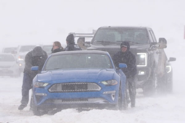 미국 북서부 지역에 겨울 폭풍이 닥치면서 유타주 리하이시에서 주민들이 눈에 빠진 자동차를 밀고 있다. /사진=AFP