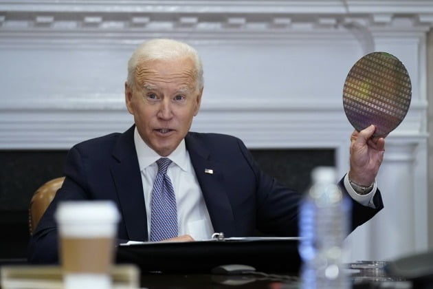 조 바이든 미국 대통령이 2021년 4월 백악관 루즈벨트룸에서 반도체 업계 대표들과 화상 회의를 진행하는 도중 실리콘 웨이퍼를 꺼내들고 있다. 연합뉴스