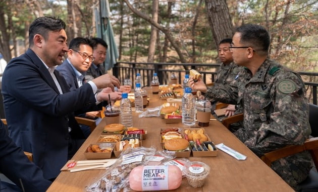 22일 송현석 신세계푸드 대표(왼쪽)가 육군 28보병사단 박춘식 사단장(오른쪽)에게 ‘베러미트로 만든 메뉴를 소개하고 있다.사진=신세계푸드 제공