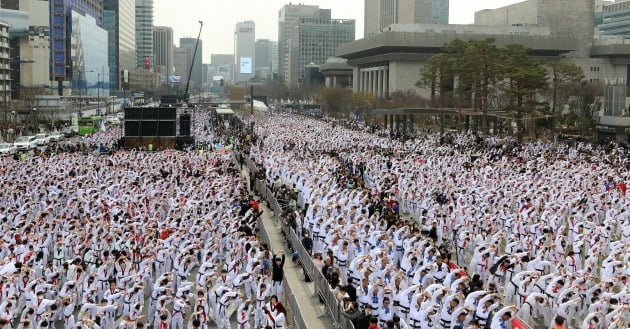 25일 오후 서울 종로구 광화문광장에서 열린 '2023 국기 태권도 한마음 대축제'에 참석한 태권도 수련인 1만2천여 명이 태권도 태극 1장 품새 동작을 선보이는 기네스 도전을 앞두고 몸을 풀고 있다. /사진=뉴스1