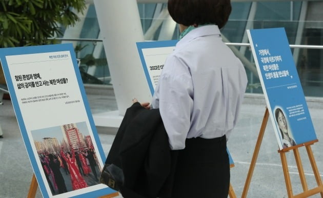 한 여성이 30일 오전 서울 영등포구 여의도 국회 의원회관에서 열린 북한인권 위한 국제사회의 노력과 북한여성인권 사진 전시회에서 전시물을 살펴보고 있다. 뉴스1