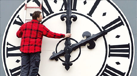 독일의 한 교회에서 시계 기술자가 서머타임 시행에 맞춰 시간을 조정하고 있다.  한경DB 
