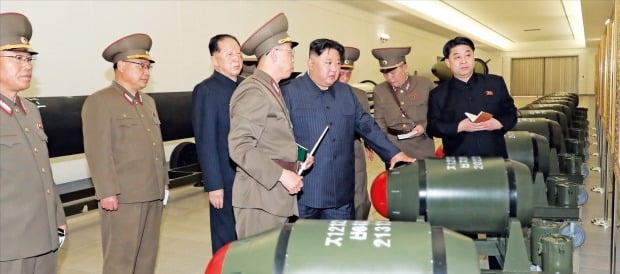 < 北 신형 핵탄두 ‘화산-31’ > 북한이 28일 신형 전술핵탄두 ‘화산-31’을 전격 공개했다. 조선중앙통신은 “김정은 북한 국무위원장이 전날 핵무기병기화사업을 지도한 자리에서 핵무기연구소와 원자력 부문에서 핵무기 보유량을 기하급수적으로 늘릴 것을 주문했다”고 밝혔다. 김정은이 신형 핵탄두에 손을 얹고 군 관계자로부터 전술핵탄두에 대해 설명을 듣고 있다.  연합뉴스 