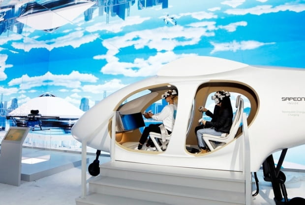 미국 가전·IT 박람회 'CES 2023' SK그룹관에서 관람객들이 SK텔레콤의 도심항공교통(UAM) 모형에 탑승해 운행 체험을 하고 있다. 사진=SK