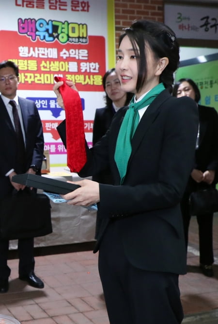 김건희 여사가 윤석열 대통령이 착용했던 빨간 넥타이를 기부하는 모습. 연합뉴스