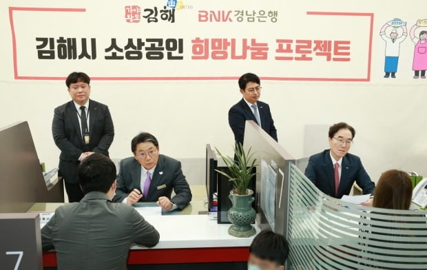 BNK경남은행 예경탁 은행장(오른쪽)과 김해시 홍태용 시장이 지역 소상공인들에게 경영애로ㆍ금융 상담과 경영컨설팅 등을 제공하고 있다. 경남은행 제공. 