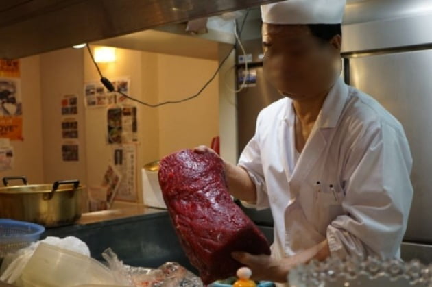 도쿄의 한 식당에서 요리사가 고래고기를 들고 있는 모습. /사진=연합뉴스 