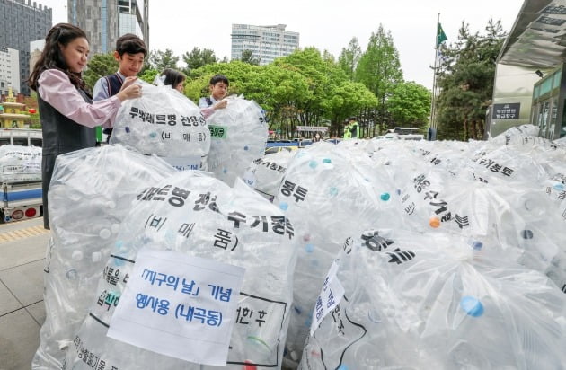 지구의 날을 하루 앞둔 21일 서울 서초동 서초구청에서 열린 '서초구 탄소중립 실천을 위한 체험행사'에서 어린이들이 주민들이 모은 투명페트병을 전용 수거차량으로 옮기고 있다. 