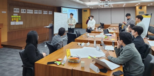 KT 직원들이 21일 ‘2023 그룹 DX 원팀’ 프로젝트 과제 수행을 위해 토론하고 있다.  /KT 제공