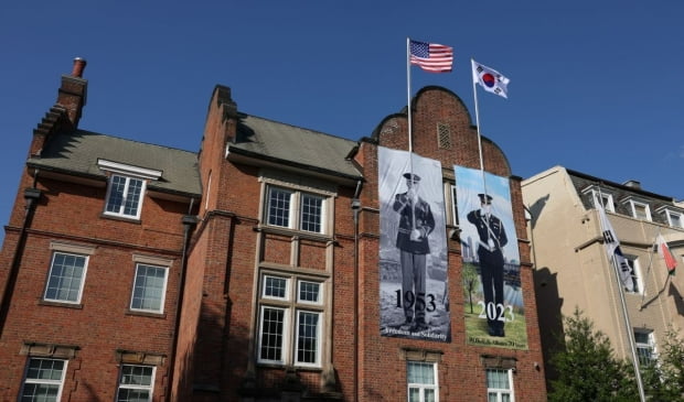 워싱턴DC 매사추세츠가에 위치한 주 워싱턴 한국문화원 외벽에 1953년 미국 의장대와 2023년 대한민국 의장대가 나란히 서서 한미 양국 국기를 들고 서 있는 모습이 게시된 모습. 대통령실 제공