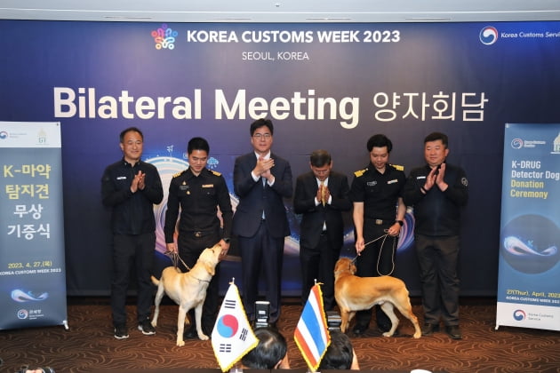 한국세관 직원이 태국세관 직원에게 마약탐지견을 전달하고 있다