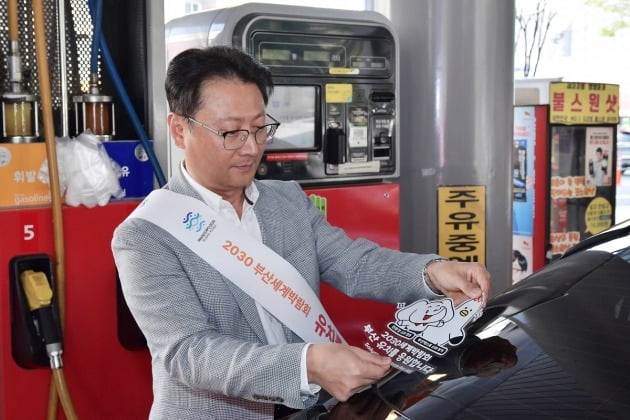 오종훈 SK에너지 P&M CIC 대표가 부산엑스포 유치 기원 차량부착용 스티커를 부착하고 있다. 사진=SK에너지 제공