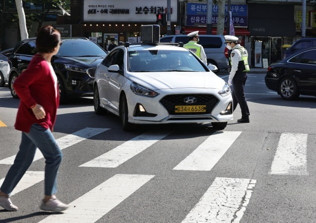 경찰들이 우회전 일시 정지 위반 차량 단속을 하고 있다. 사진=한국경제신문