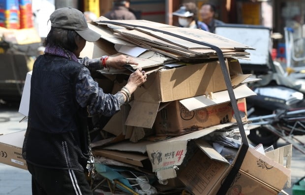 서울의 고물상 앞에서 한 노인이 리어카에 쌓인 폐지를 정리하고 있다. 사진=뉴스1