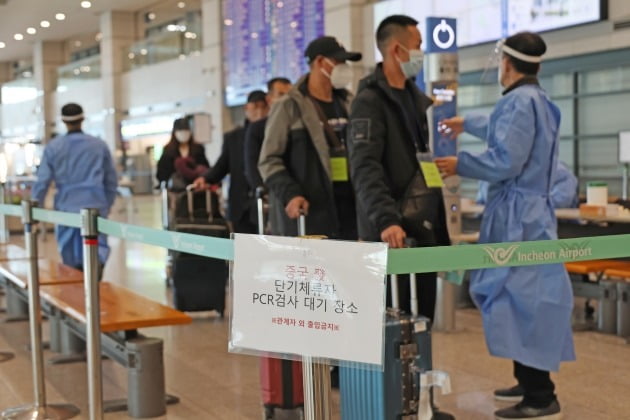 중국에서 들어온 입국자들이 인천국제공항 제1여객터미널에서 PCR검사를 받기 위해 대기하고 있는 모습. 코로나 위기경보가 하향 조정되면 해외 입국자에 대한 검사도 없어지게 될 전망이다. 한경DB