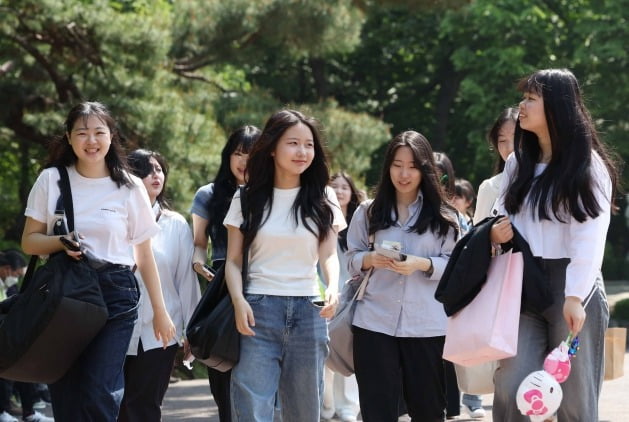 정부가 코로나19 방역조치를 대부분 해제하며 사실상 엔데믹을 선언한 11일 서울 광진구 어린이대공원으로 졸업사진을 찍기위해 방문한 고3학생들이 마스크를 벗고 대화를 나누고 있다. 