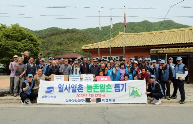 지난 12일 강원도 영월 덕전마을을 찾은 신동아건설 임직원들이 봉사활동을 마친 뒤 마을 주민들과 기념촬영을 하고 있다./신동아건설 제공
